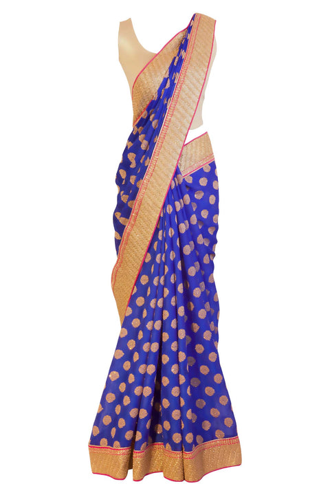 Royal blue chiffon sari with gold pin wheels embroidery. Heavy gold border with pink trim.  