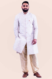 Kurta style sherwani, silk blend with a with gold buttons from collar to mid torso. This kurta is paired with a neutral color pants.