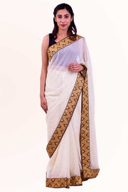 Angelic cream chiffon sari covered in gold specks, with heavy golden border designed with bindi appearing details.