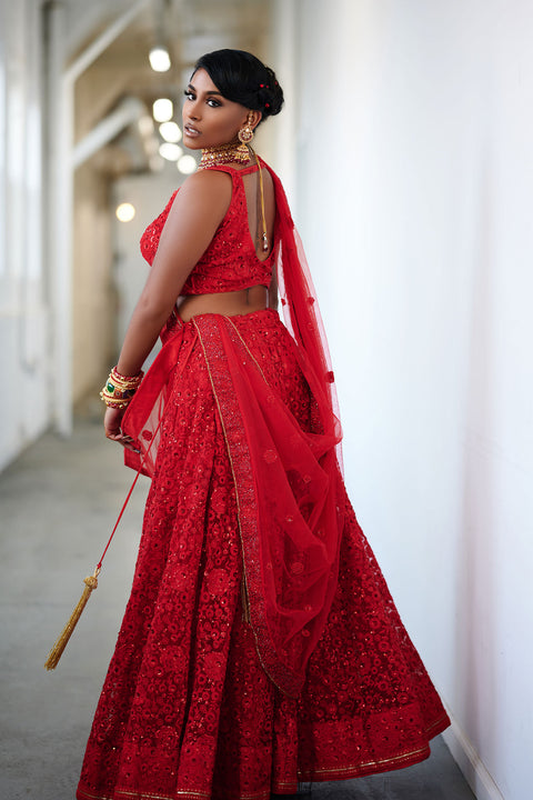 Burn fiercely  Red net lehenga with intricate flower work on lehenga and blouse.  Comes with matching dupatta.   Skirt Length: 42 inches (Can not be altered)  Note: Blouse style and complimentary jewelry may vary depending on size and availability.
