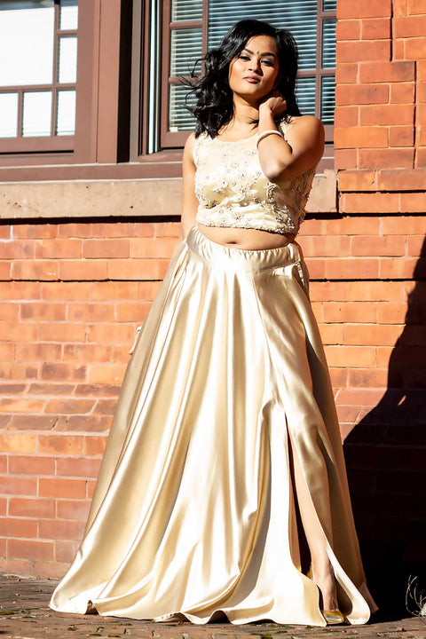 Elegant two piece silk champagne lehenga. Side slit on skirt for edgy look, paired with flower beading work on blouse