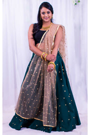 Dramatic two piece lehenga with rich green skirt covered in gold embroidered polka dots. Paired with black blouse. Finish this look with color blocking net gold dupatta with matching polka dots as skirt on shoulders/ shoulder.