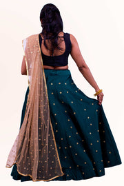 Dramatic two piece lehenga with rich green skirt covered in gold embroidered polka dots. Paired with black blouse. Finish this look with color blocking net gold dupatta with matching polka dots as skirt on shoulders/ shoulder.