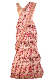 Gorgeous pink floral chiffon sari with embroidered border with pink trim and printed flowers through out the saree. Paired with beige blouse.