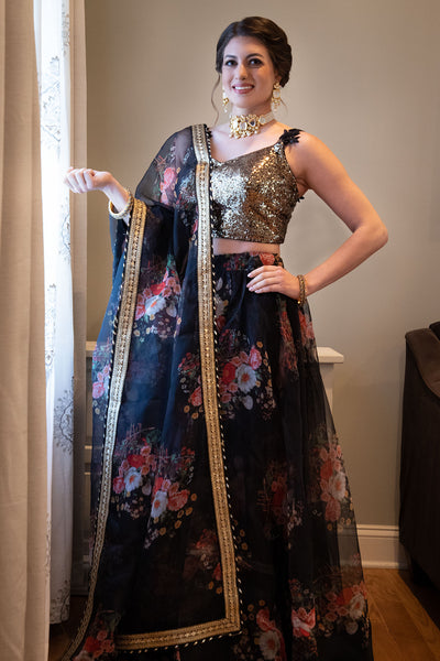 There’s always a wild side to an innocent face.  Colorful two piece black lehenga, skirt covered in pink and white hued flowers.  Skirt Length: 42 inches   Note: Blouse style and complimentary jewelry may vary depending on size and availability.
