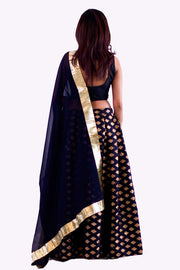 Beautiful two piece silk lehenga, paired with cropped black blouse. Skirt is covered in golden embroidered square pattern. Finish this look by draping black chiffon dupatta with bright gold border on shoulders/ shoulder.