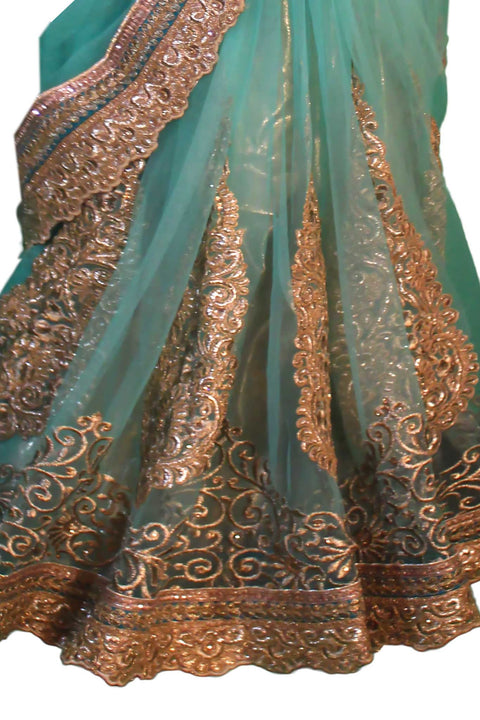 Magnetic light blue/ teal net sari with traditional hand crafted golden embroidery. Heavy pallu detail.