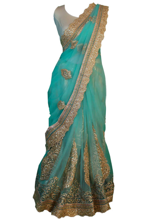 Magnetic light blue/ teal net sari with traditional hand crafted golden embroidery. Heavy pallu detail.