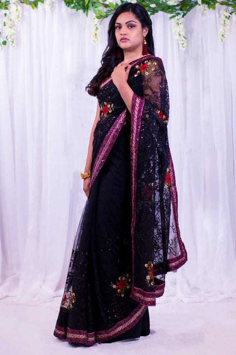Black berry net sari with pink sequenced border, with embroidered red roses & green leaves.