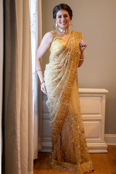 I can see you on the Forbes list. Gold net sari with gold embroidery, paired with a gold blouse.  Note: Sari comes with a petticoat and blouse. If you prefer blouse with sleeves please specify in your order.