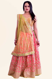 Peachy pink lehenga with complex gold threading designed through entire skirt paired with golden blouse. Finish this look with draping the net color blocking dupatta on shoulders/ shoulder. 