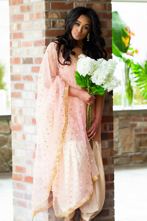 Elegant pink kurta covered in scalloped gold work, paired with matching ruffled pants designed with a draw string to fit any size waist. Finish this look with matching pink glittery dupatta by draping it on shoulder.