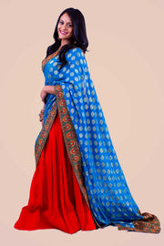 Phenomenal color blocking two piece lehenga, bright red skirt paired with golden blouse. Blue dupatta is focal point of this look, designed with heavy red and orange embroidered border.