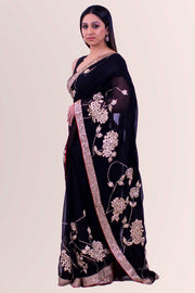 Majestic black chiffon sari with heavy gold border with dainty red trim.