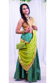 Sparkling two piece lehenga, skirt covered in beautiful teal silk work, paired with gold blouse. Finish this look by draping light kiwi green chiffon dupatta decked in gold border on shoulders/shoulder.